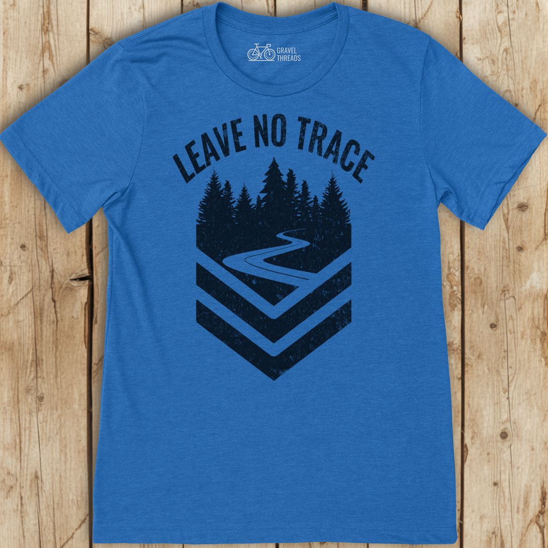 Blue t-shirt with 'Leave No Trace' graphic on a wooden surface