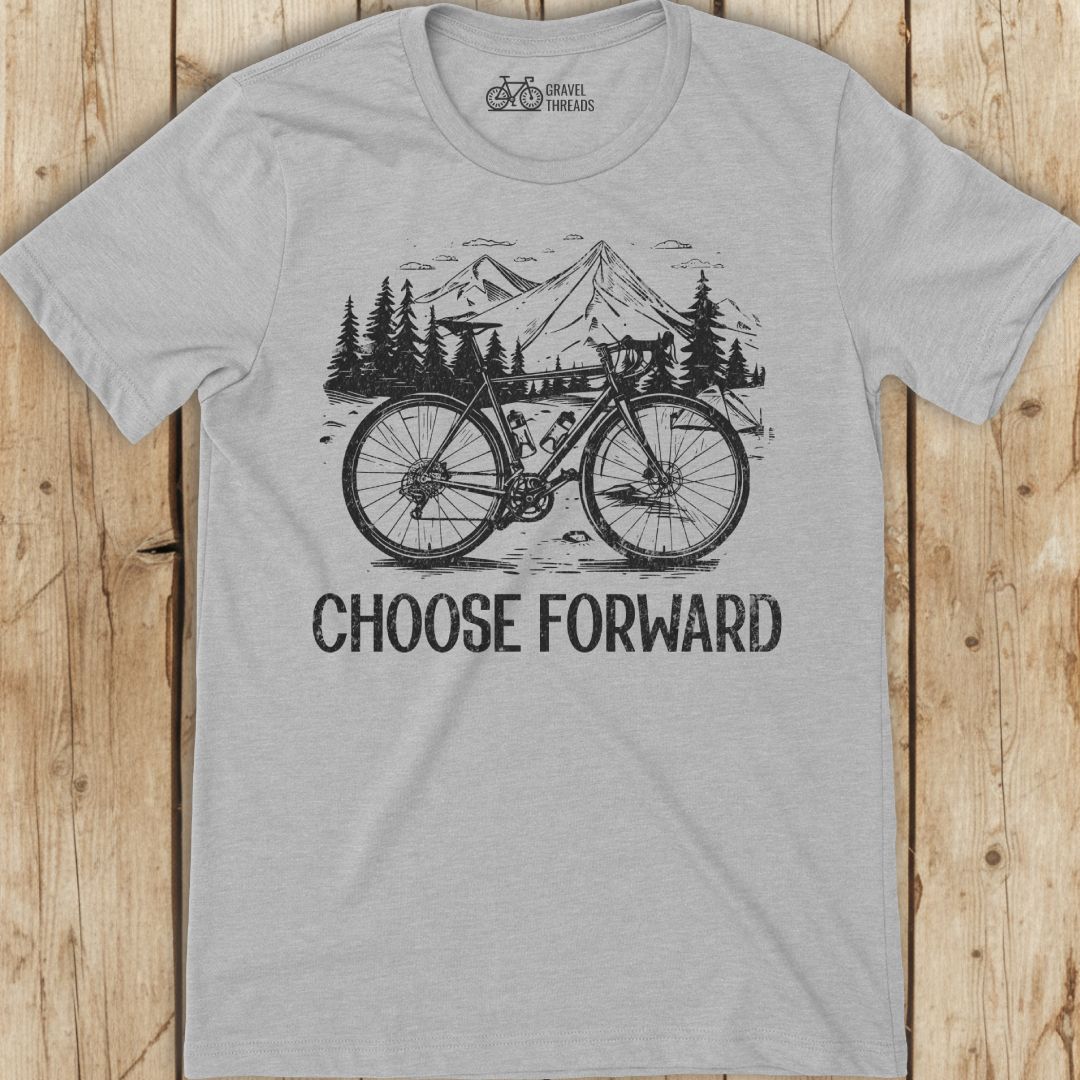 Gray t-shirt with bicycle graphic and 'Choose Forward' text on a wooden surface
