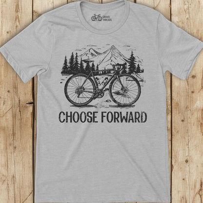 Gray t-shirt with bicycle graphic and 'Choose Forward' text on a wooden surface