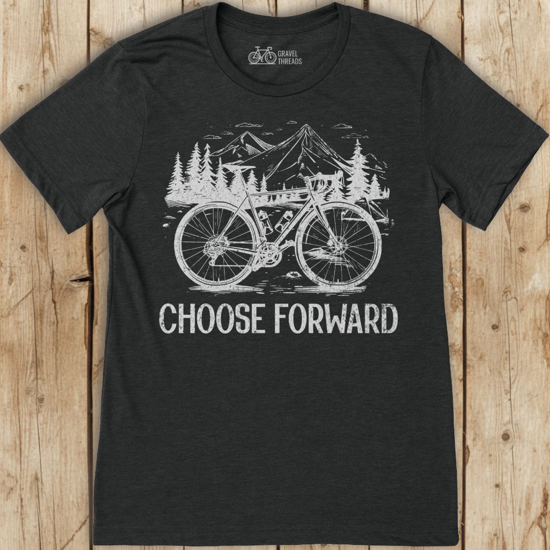 Black t-shirt with a bicycle graphic and 'Choose Forward' text on a wooden surface