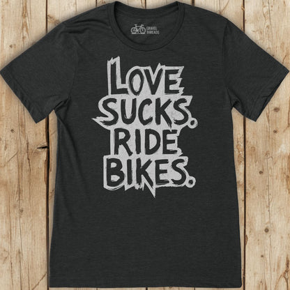 Black t-shirt with 'Love sucks, ride bikes' text on a wooden surface