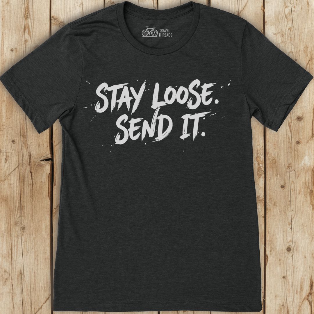Black t-shirt with 'Stay Loose. Send It.' text on a wooden background