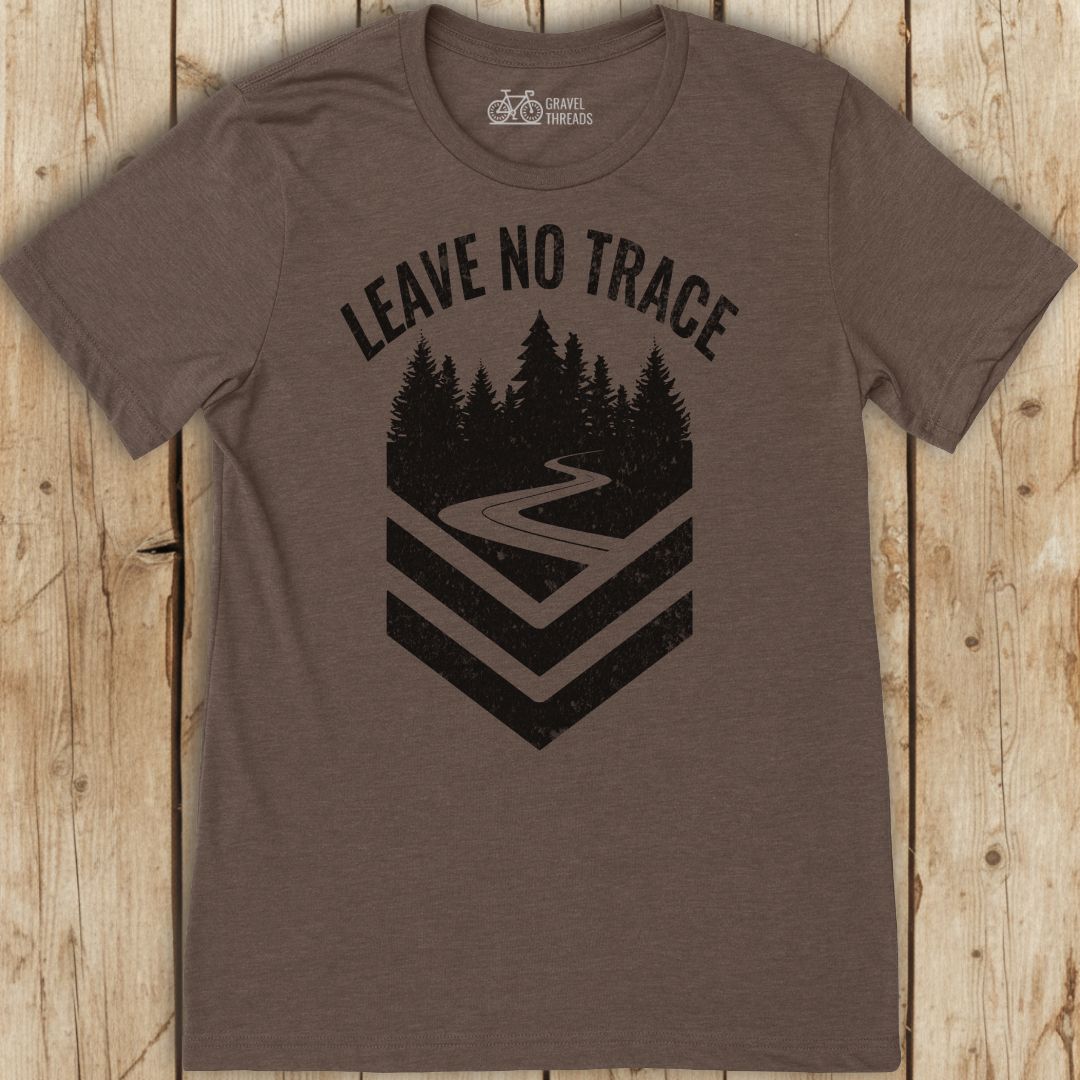 Brown t-shirt with 'Leave No Trace' graphic on a wooden surface