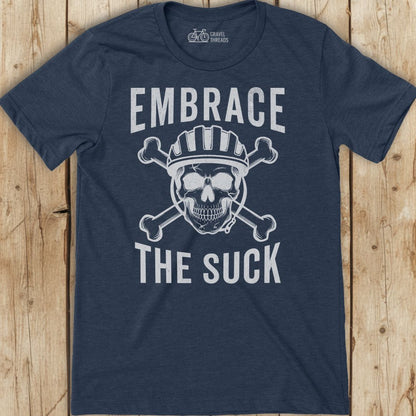 Navy blue t-shirt with skull graphic and text 'Embrace The Suck' on a wooden surface