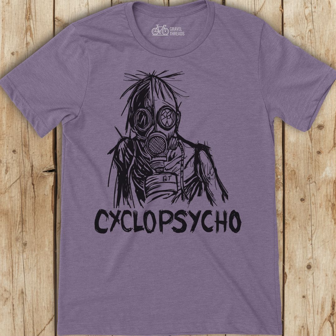 Purple t-shirt with a graphic design and 'Cyclopsycho' text on a wooden surface
