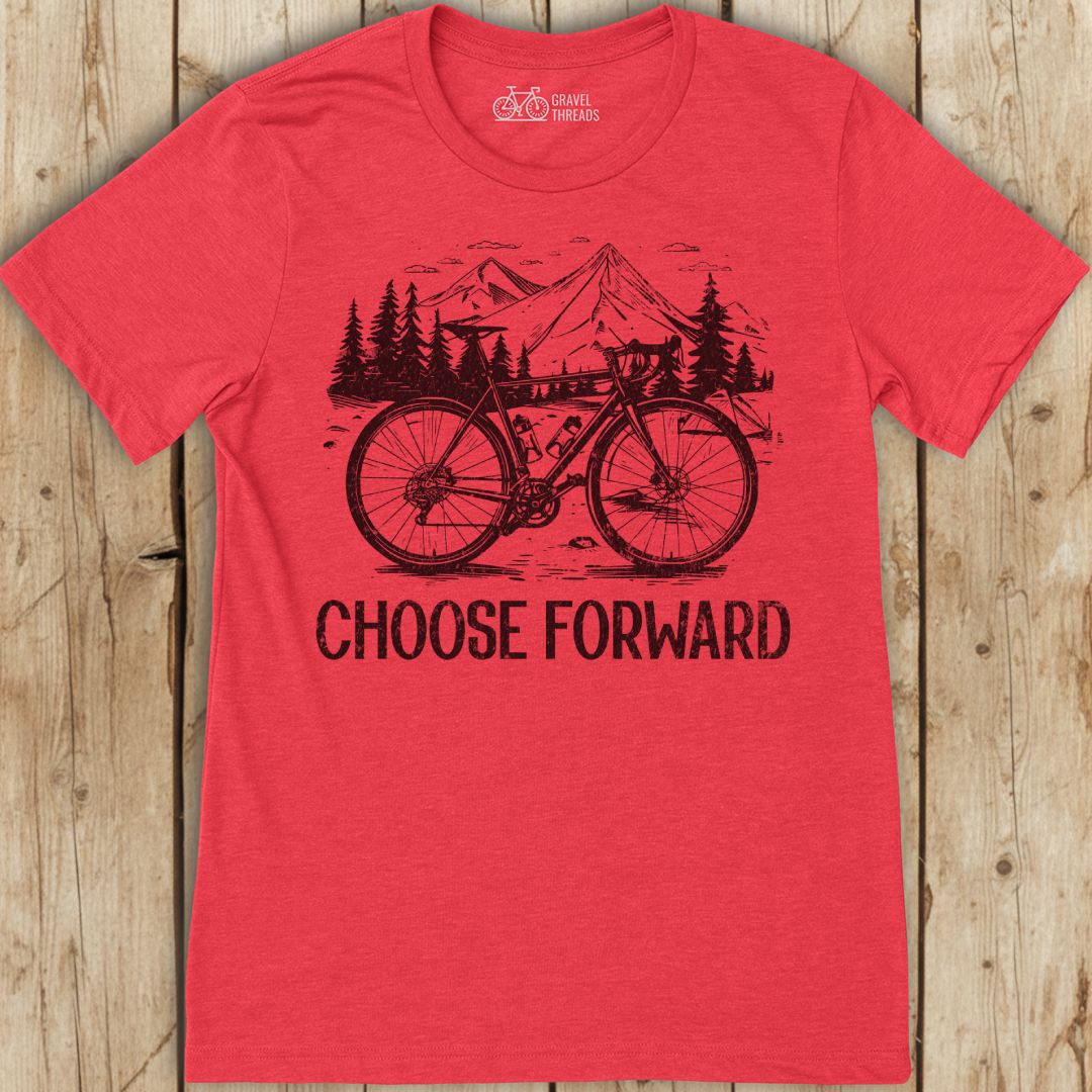 Red t-shirt with bicycle graphic and 'Choose Forward' text on a wooden background