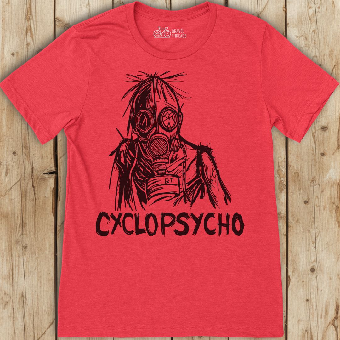 Red t-shirt with black graphic design and 'Cyclopsycho' text on a wooden surface