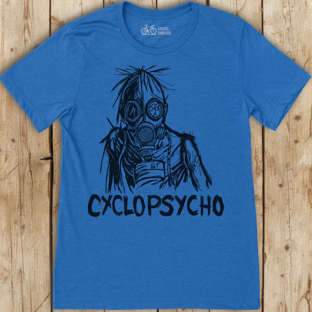Blue t-shirt with a graphic design and 'Cyclopsycho' text on a wooden surface
