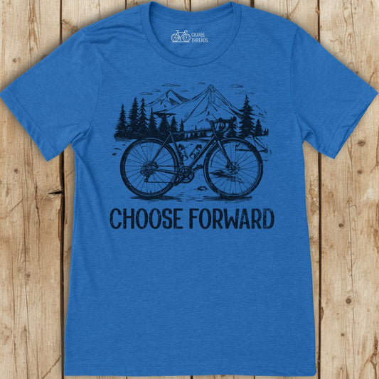 Blue t-shirt with bicycle graphic and 'Choose Forward' text on a wooden surface