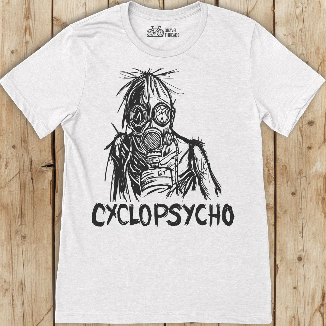 White t-shirt with black graphic design and 'Cyclopsycho' text on a wooden surface